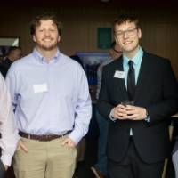 Four attendees at event standing together and smiling for camera